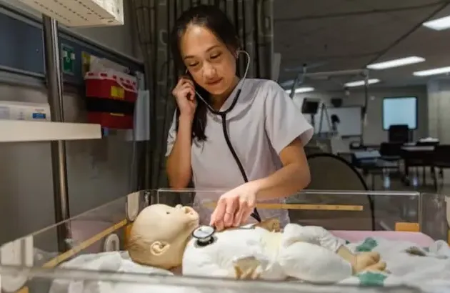 护理 student with practice baby dummy